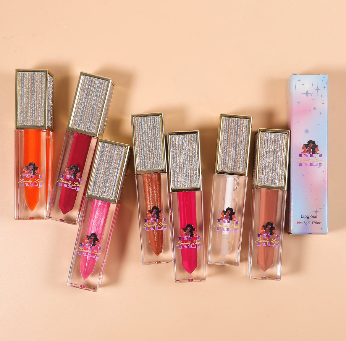 Set of lip glosses with decorative packaging on a beige background